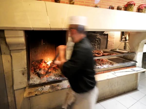 Le grillardin devant la cheminée, les braises de sarments sous la grille