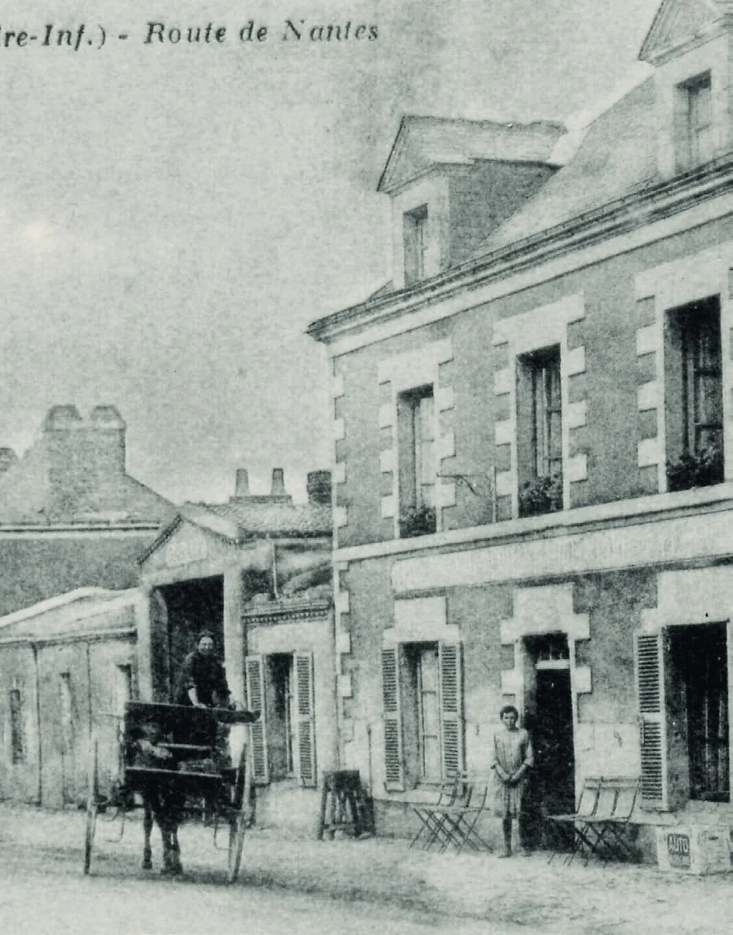 Carte postale ancienne : la route de Nantes, une carriole devant les maisons du bourg