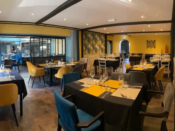 Salle dressée pour un groupe, chaises bleues et jaunes, nappes noires